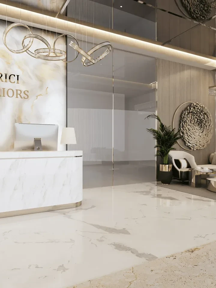 Reception Interior Design — a white marble desk and a lit logo on a veined marble wall